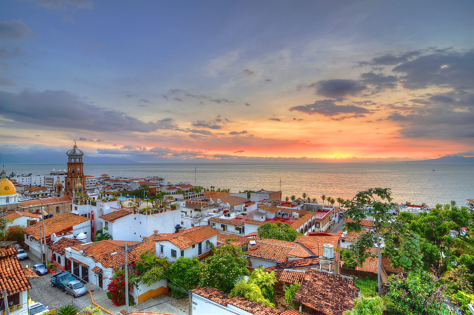 Atardecer sobre el centro de Puerto Vallarta, con la parroquia de Nuestra Señora de Guadalupe y la Bahía de Banderas